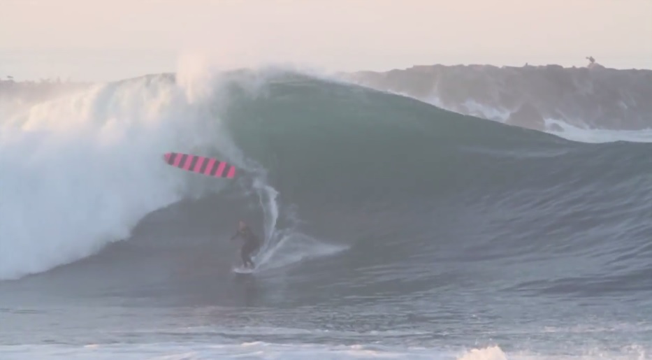 Jamie O’Brien doing a board transfer at the Wedge on an epic day